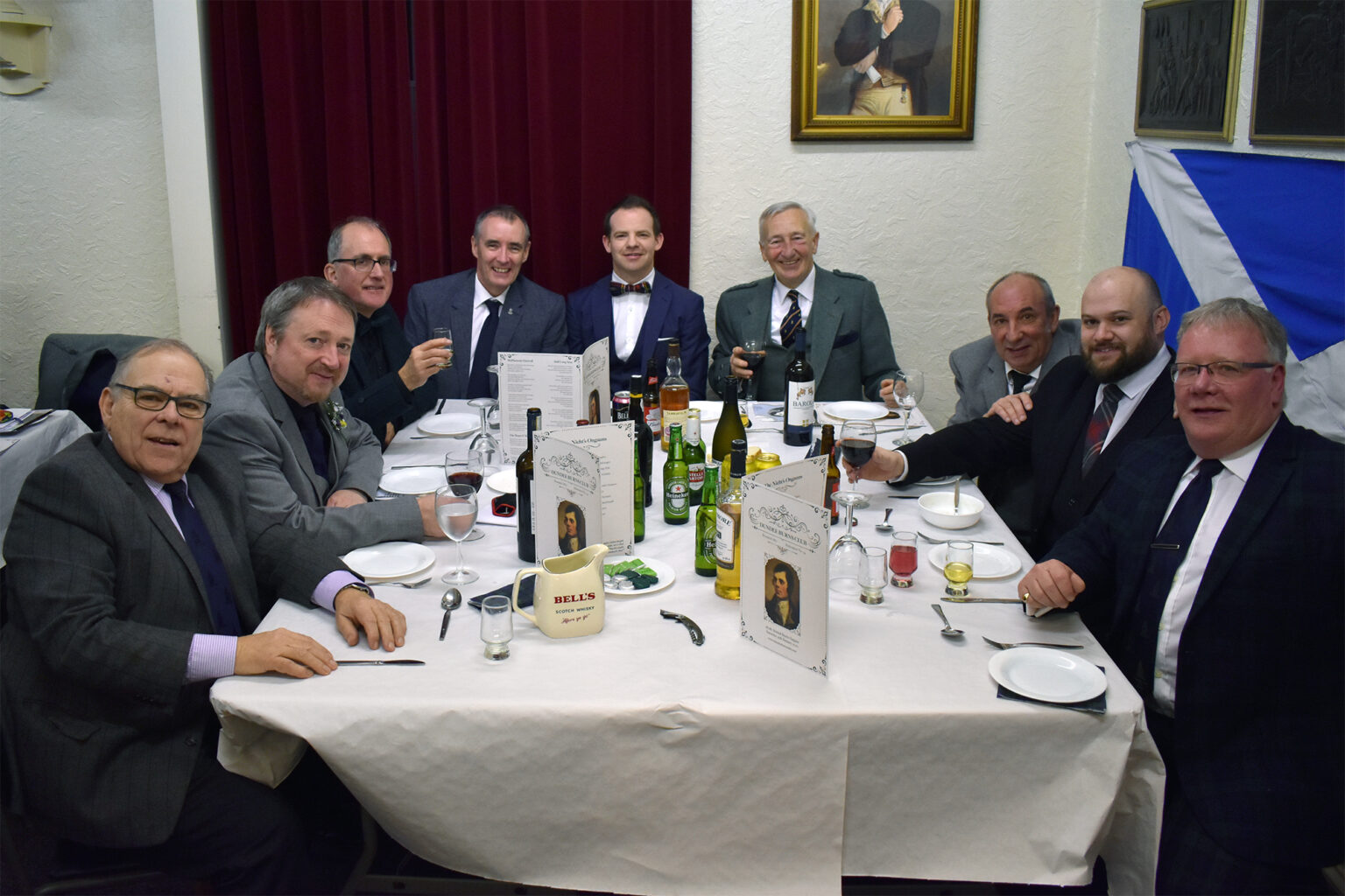Diners smile for the camera around a supper table