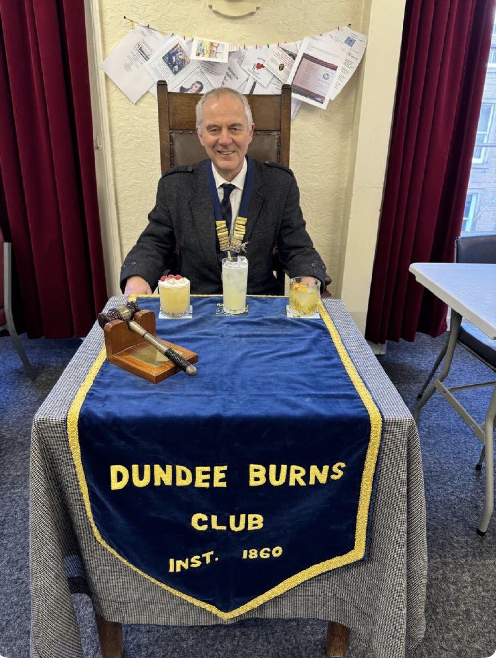 Club President Jimmy Black, wearing the chain of office, judges three cocktails at the club