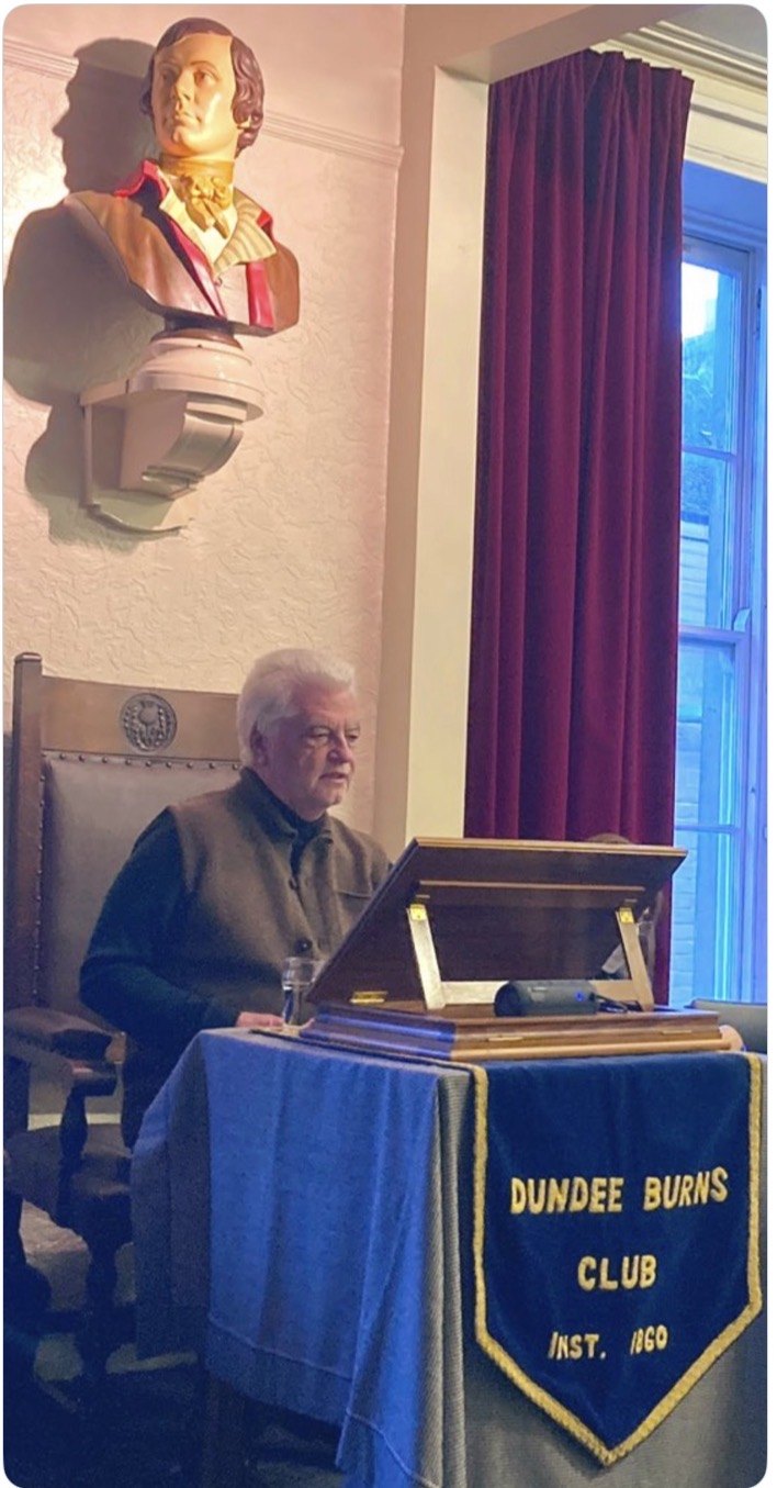 Scots language author Billy Kay speaks at the lectern beneath the bust of Burns